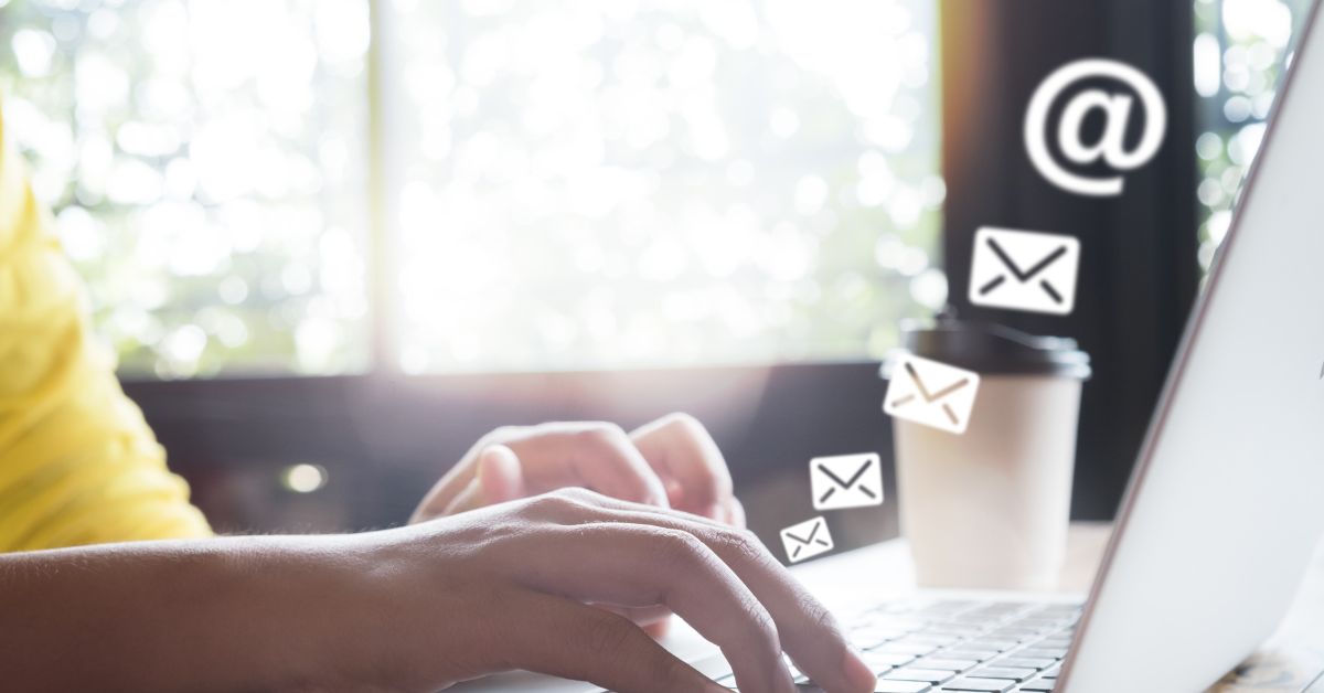 Graphic showing a person on a laptop with email icons floating away The Local Marketer