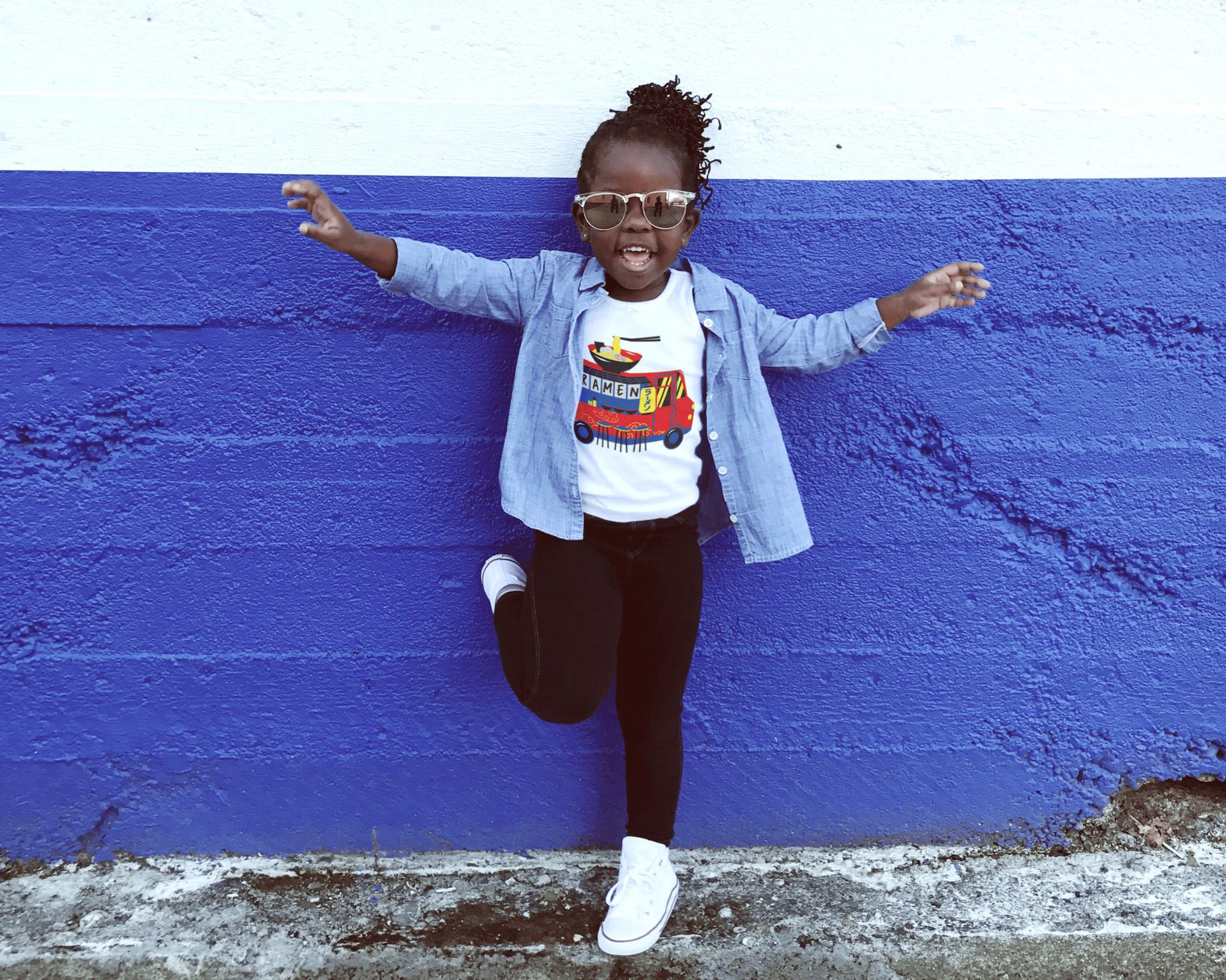 African-American girl wearing a T-shirt top outdoors wearing Ramen food truck tshirt.