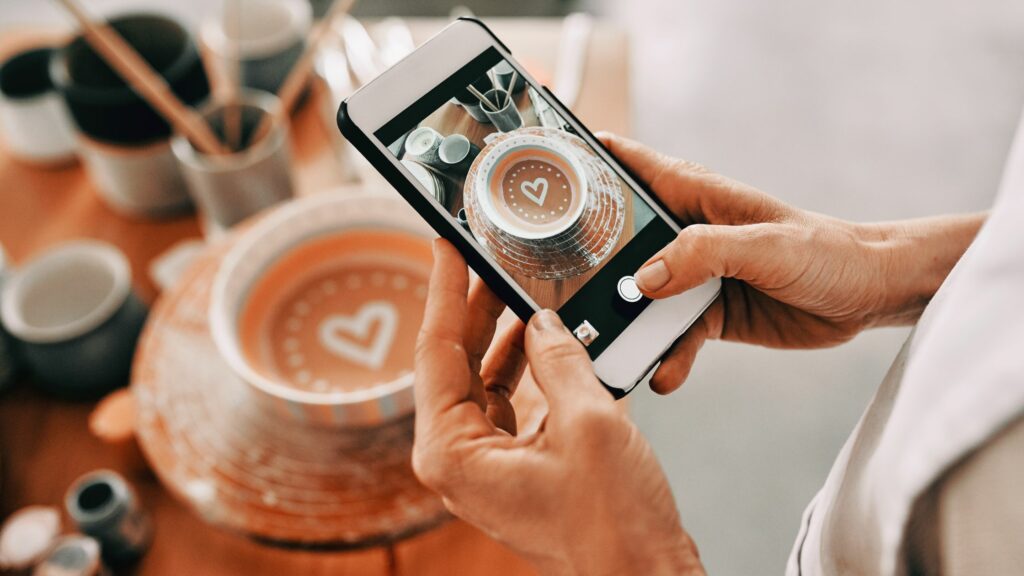 Photo of a business owner taking a photo for social media marketing.