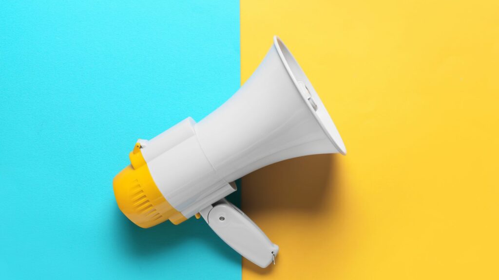 Graphic of a megaphone on a blue and yellow background